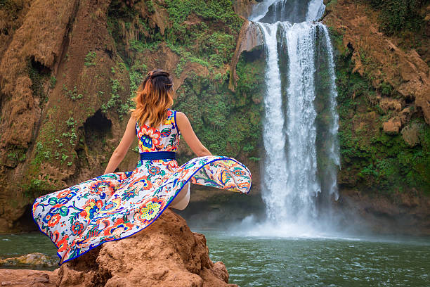 Beautiful waterfall in Morocco. Back woman beautiful dress looking fall Ouzoud Grand Atlas. Exotic nature North Africa