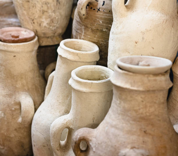 A collection of handmade clay pots sits on display at a market. These traditional earthenware vessels reflect the rich artisanal heritage of Moroccan craftsmanship